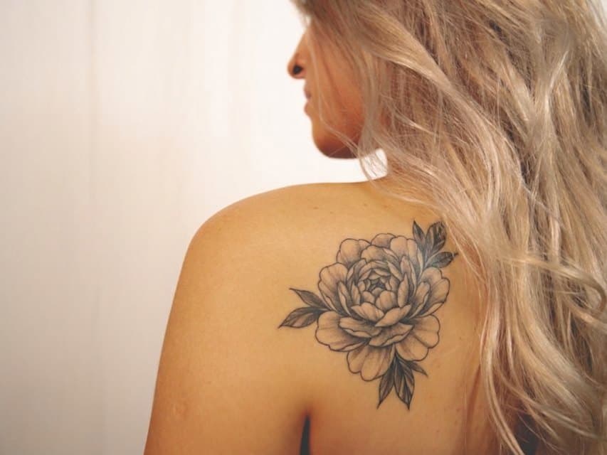 Épaule avec un tatouage pivoine black & grey généré par TattooAI